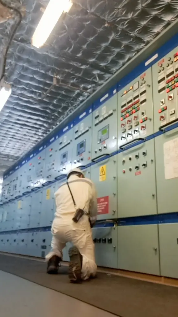 Engineer at a ship's main switchboard in the engine control room