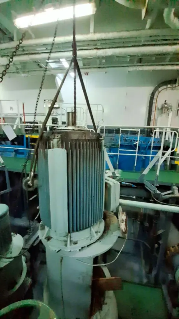 Electric motor lifted for overhaul in an engine room