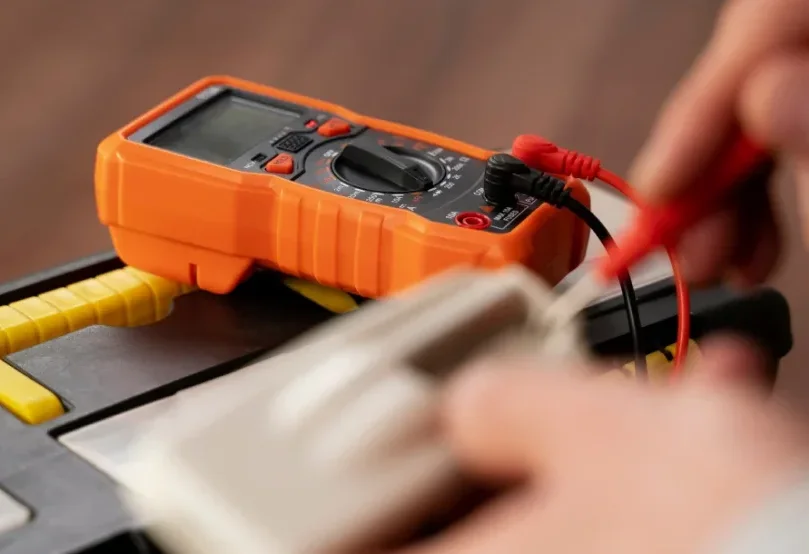 Digital multimeter with test leads in use during an electrical diagnostic
