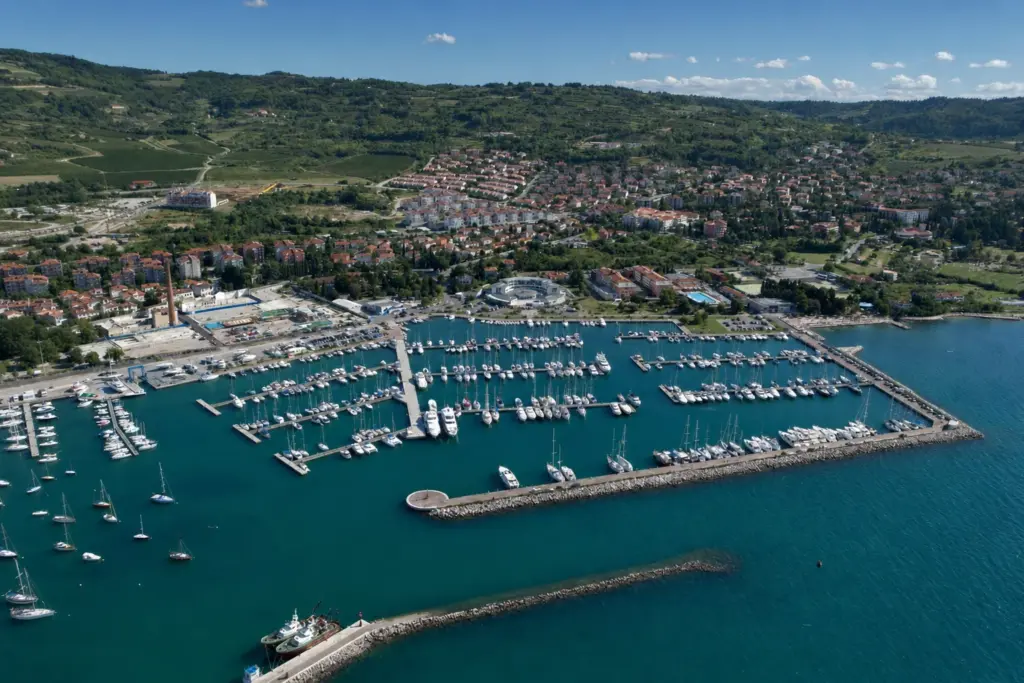 Aerial view of Marina Izola on the Slovene coast, yachts berthed along the pontoons with the hills behind